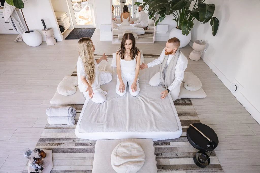5-MeO-DMT ceremony at Enfold retreat, with a woman being supported by two facilitators.