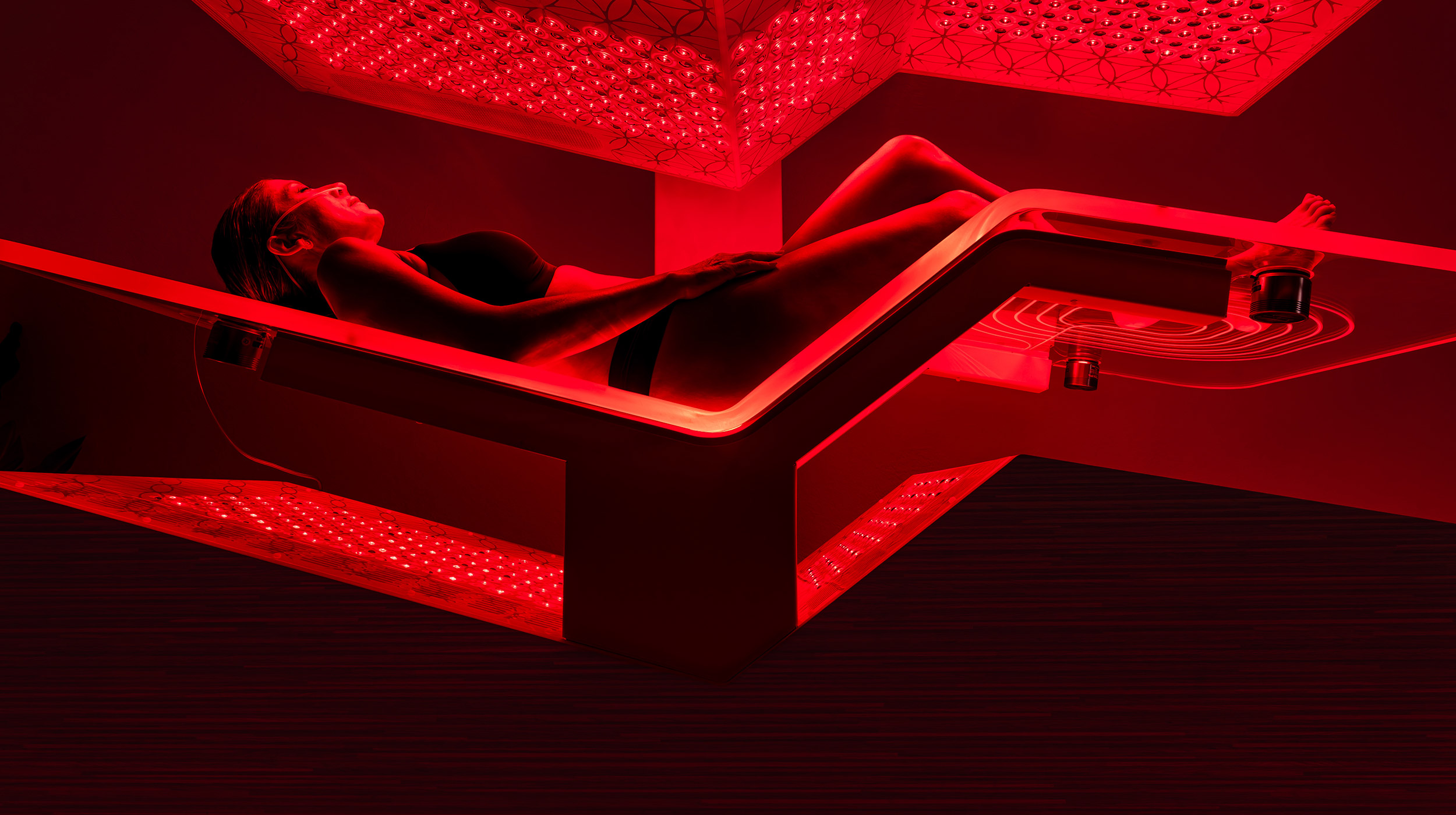 A woman laying inside the Ammortal red light biohacking chamber.