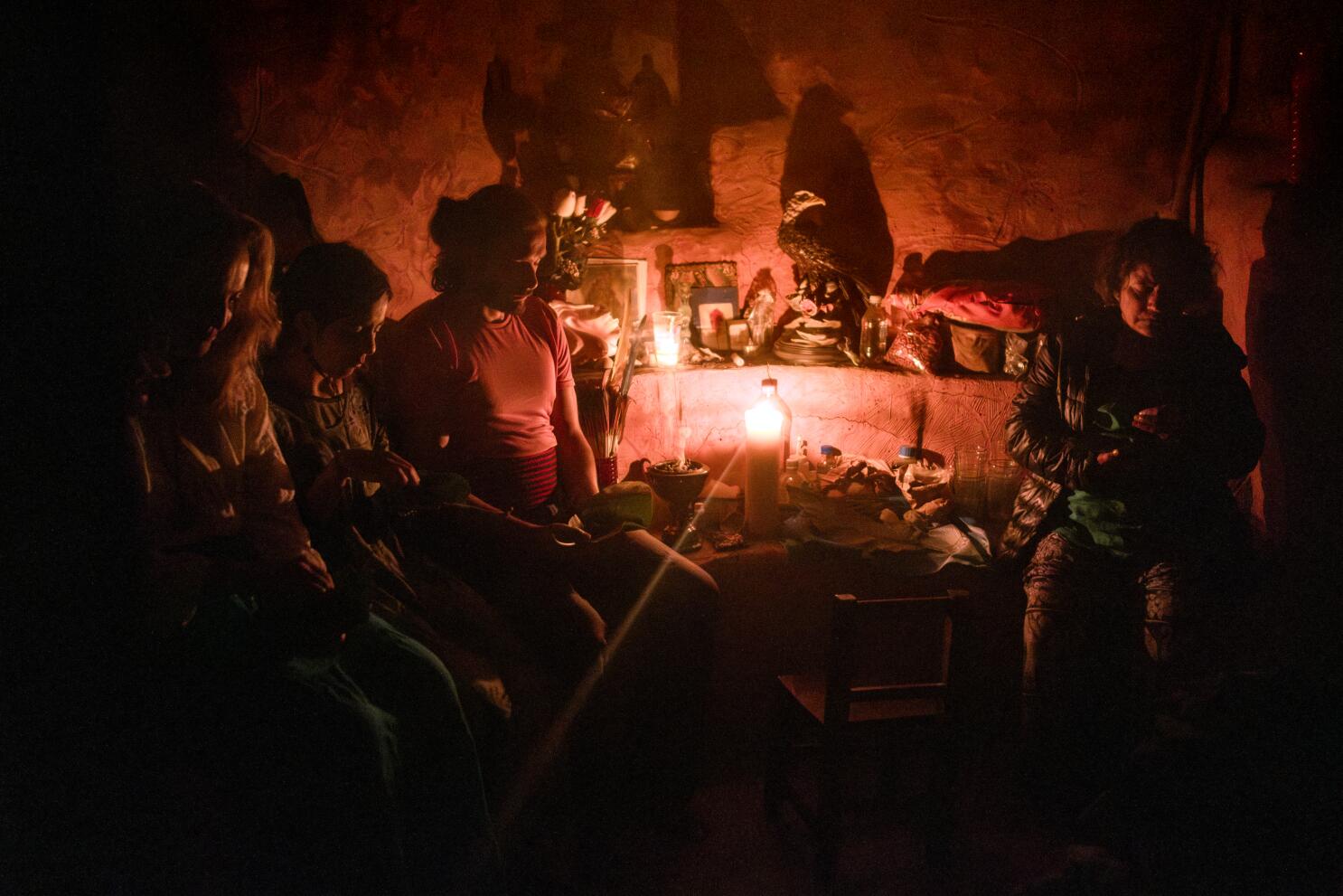 A psilocybin mushroom ceremony taking place in a dark cave with a few people.