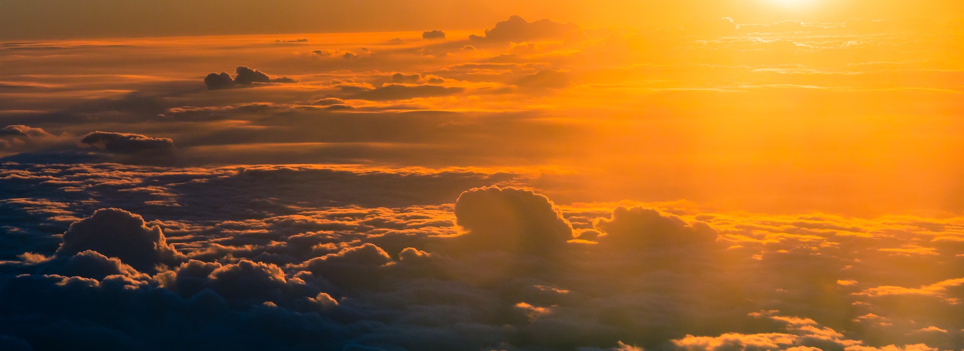 Orange hue of sunlight shining on clouds.
