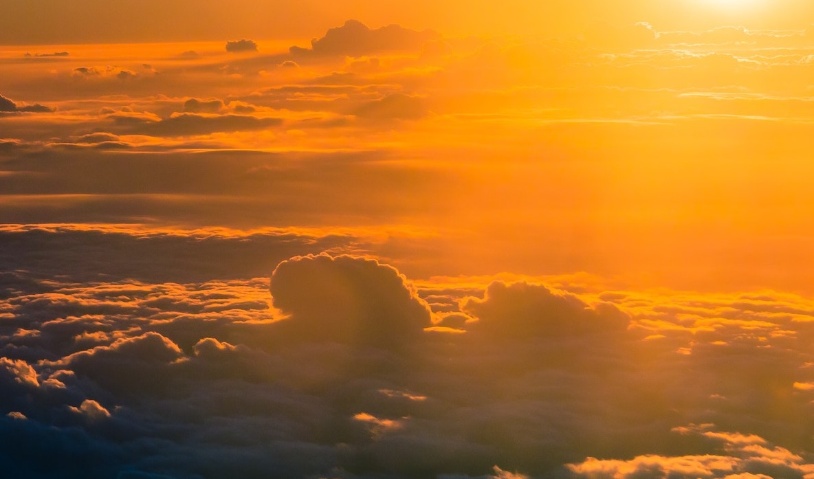 Orange hue of sunlight shining on clouds.